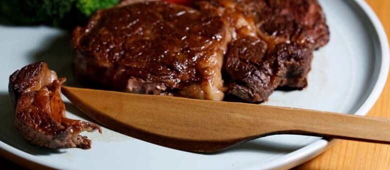 sustainabilization and sustainable products: a wooden knife on a plate